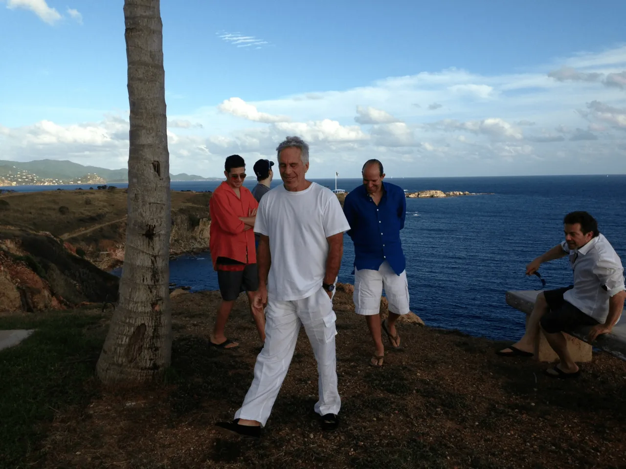 Photo from DOJ file EFTA01230639 showing Jeffrey Epstein and Howard Lutnick with several men at a coastal location