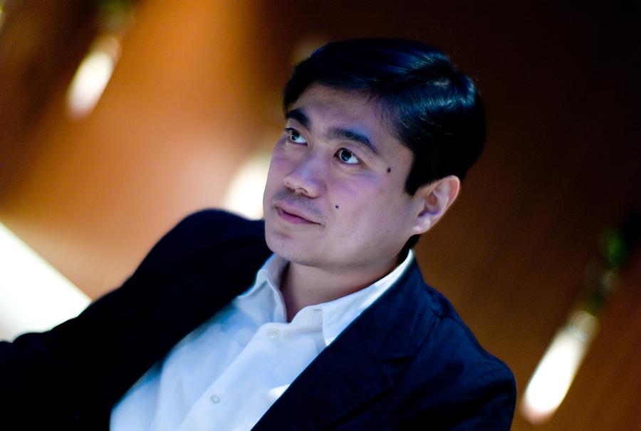 Portrait of Joi Ito in a dark jacket and white shirt